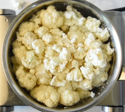 A pan of cauliflower florets boiling in a pan