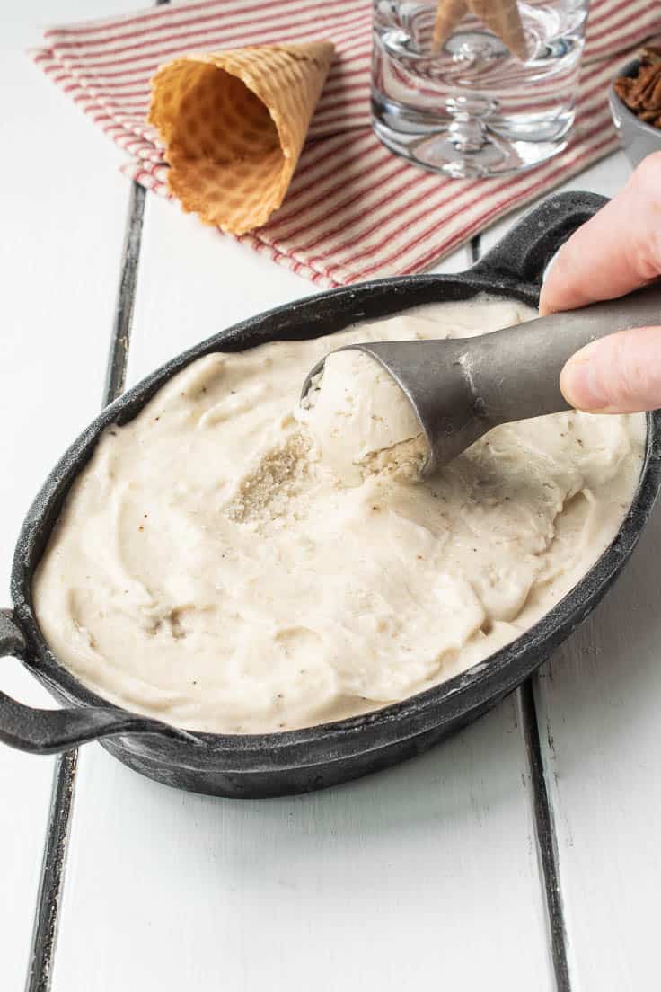 Scooping banana ice cream from an oval dish