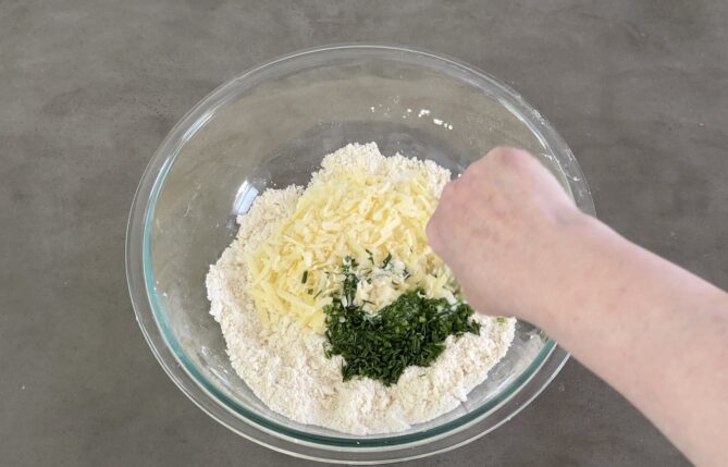 Mixing cheese and chives into flour
