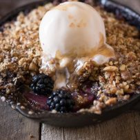 A scoop of vanilla ice cream melting into Apple spiced caramel sauce