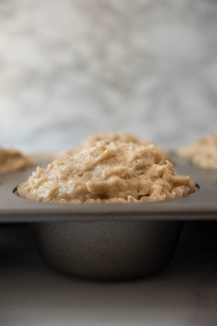 Muffin batter in a baking pan from the side