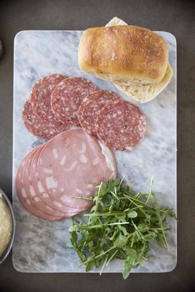 Slices of mortadella, salami, fresh arugula and a ciabatta bread roll