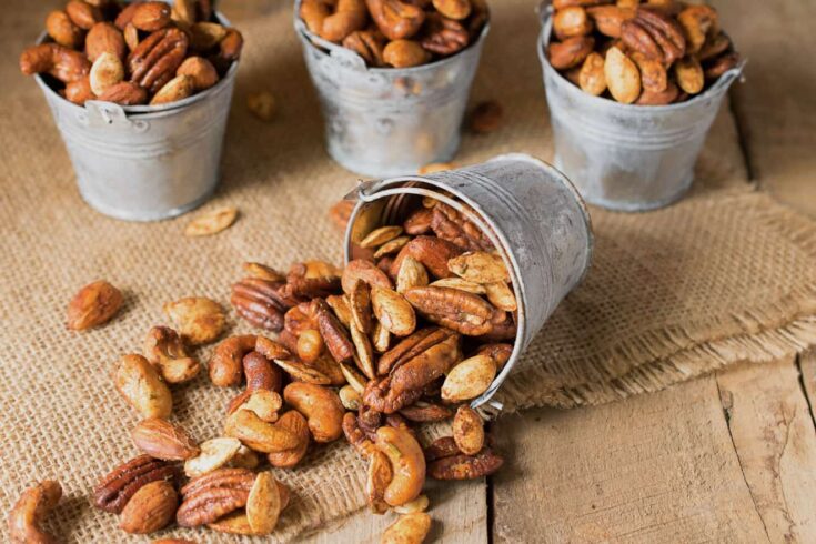Almonds, pecans, cashews and pumpkin seeds spilled out onto a mat
