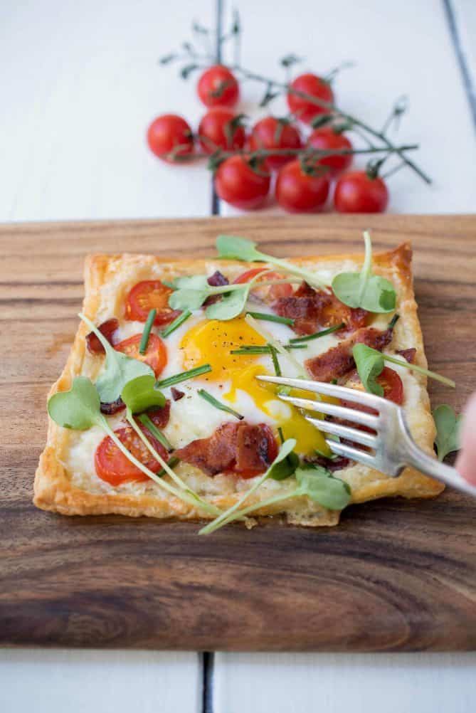 Cutting into the egg yolk that is running over the rest of the tart