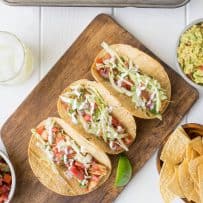 A feast of fish tacos, tortilla chips, salsa, guacamole and a lemon lime margarita