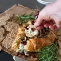 Scooping some brie onto a cracker