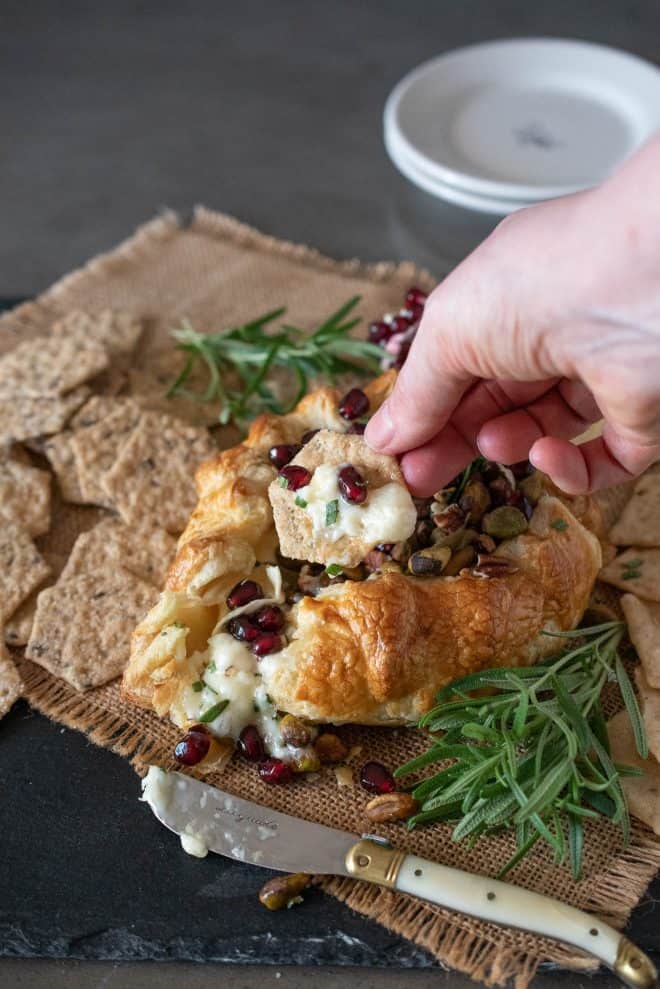 Scooping some brie onto a cracker