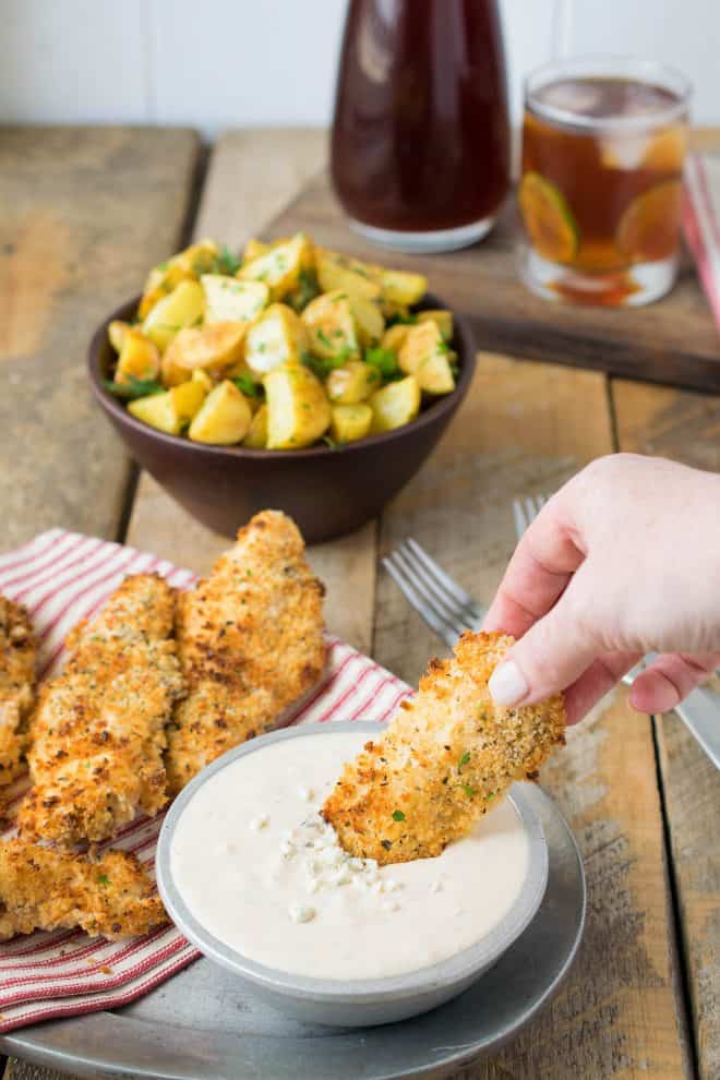 Dipping a baked chicken tender into buffalo blue cheese sauce
