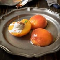 Drizzling bourbon sauce onto peach halves