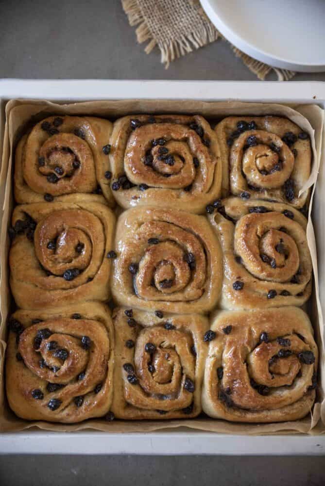 Pastry rolls with currants in a square baking dish from overhead