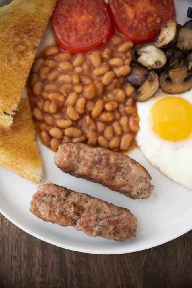 A breakfast from overhead with baked beans, toast, tomato, egg and mushrooms