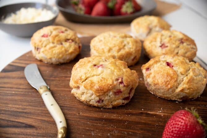 6 strawberry scones on a board with a butter knife