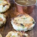 Patties on a serving board with a dish of gravy