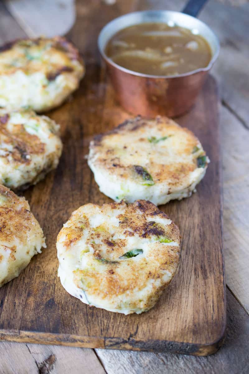 Patties on a wood board with gravy