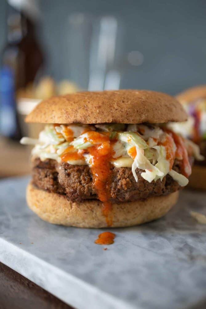 Bright orange buffalo sauce dripping down the side of a burger