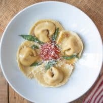 Cappellacci di zucca on a white plate viewed from overhead