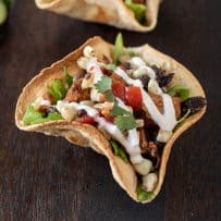Chicken tostada Salad Bowl on a board with colorful corn, tomato, cilantro