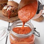 Pouring the bbq sauce into a jar