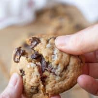Pulling apart a chocolate chunk cookie with flaky sea salt