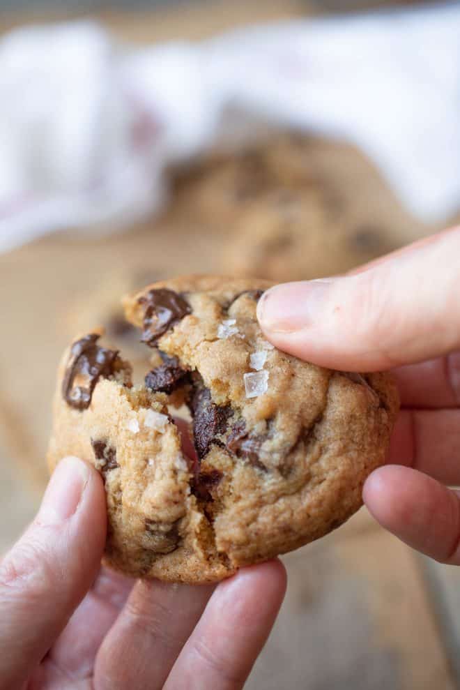 Pulling apart a chocolate chunk cookie with flaky sea salt