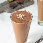 A tall glass filled with a chocolate smoothie