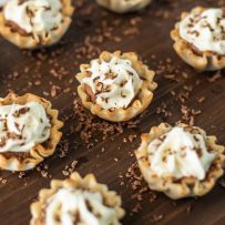 A selection of Chocolate Mousse Cream Cheese Phyllo Dessert Cups on a serving board with shaved chocolate