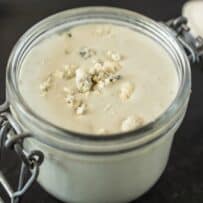 A closeup showing blue cheese crumbles in salad dressing