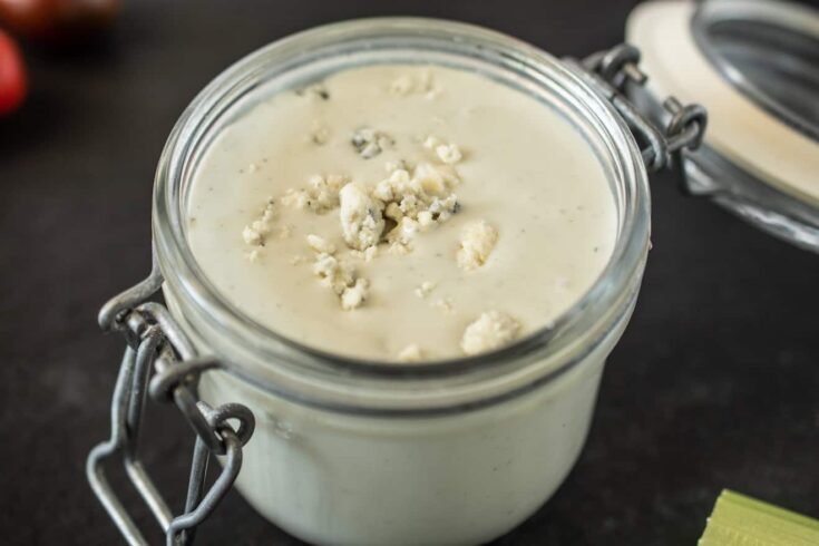 A closeup showing blue cheese crumbles in salad dressing