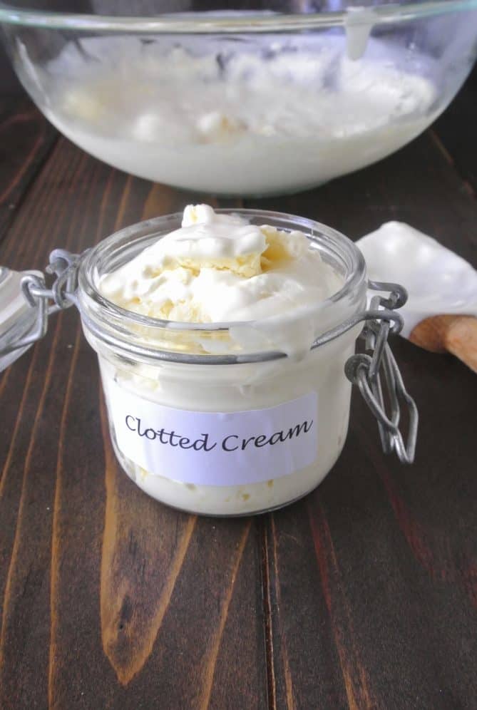 A pop-top storage jar filled with clotted cream with a label