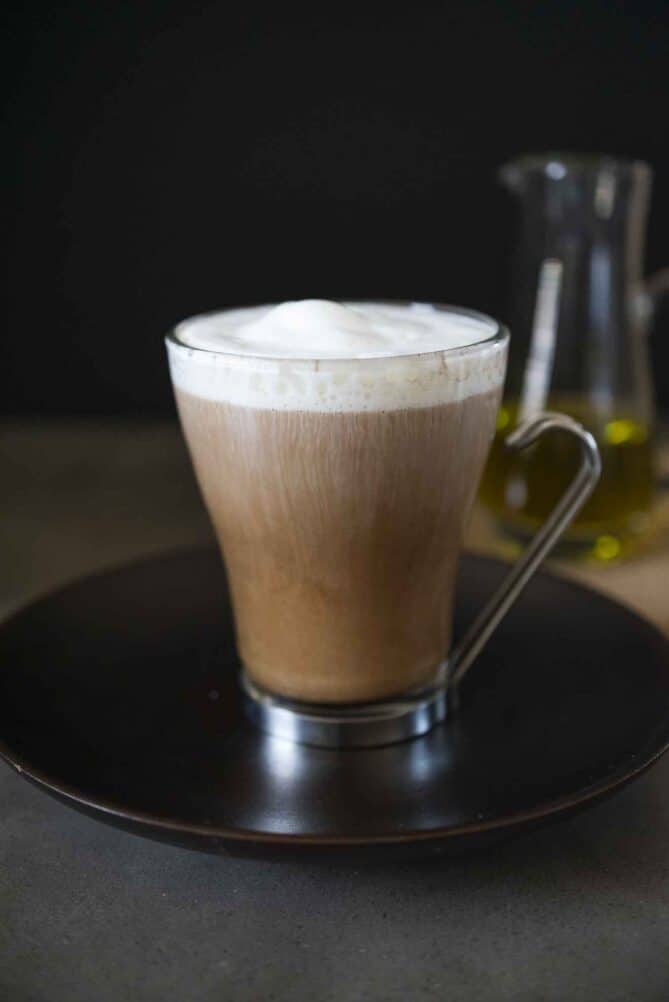 A cold brew coffee in a glass mug viewed from the side with milk