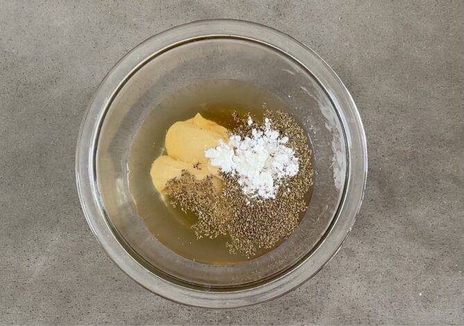 Vinegar, oil, mustard and celery seed in a glass bowl