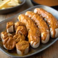 3 whole sausages and 1 cut into slices covered with currywurst sauce