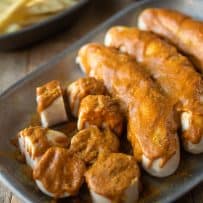 A closeup of slices German sausage covered with curry ketchup