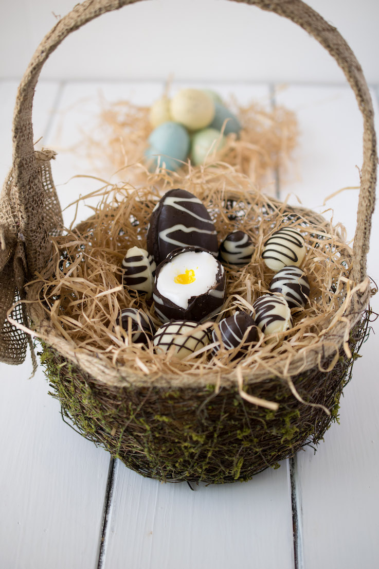 Chocolate creme eggs in an Easter basket filled with hay