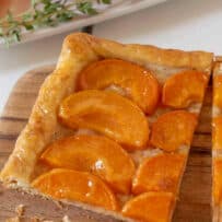 A square slice of apricot tart on a board
