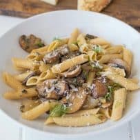 Dinner is served pasta, mushrooms, fennel and sage in a white bowl