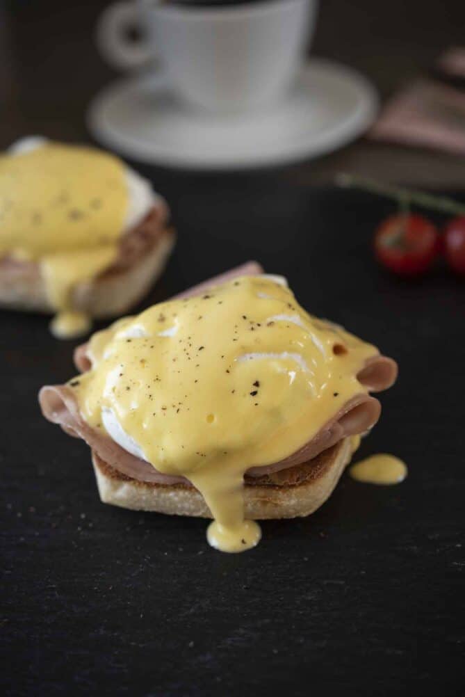 Creamy hollandaise sauce dripping off Eggs Benedict
