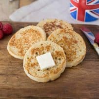 4 English crumpets with butter, berries and a cup of tea