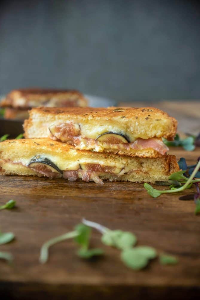 Fresh figs and prosciutto in a grilled cheese shown from the side showing the filling