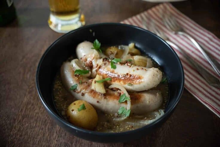 Pale sausages and potatoes stew in a bowl