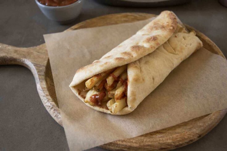 A naan wrapped around chips/French fries with Indian spiced ketchup