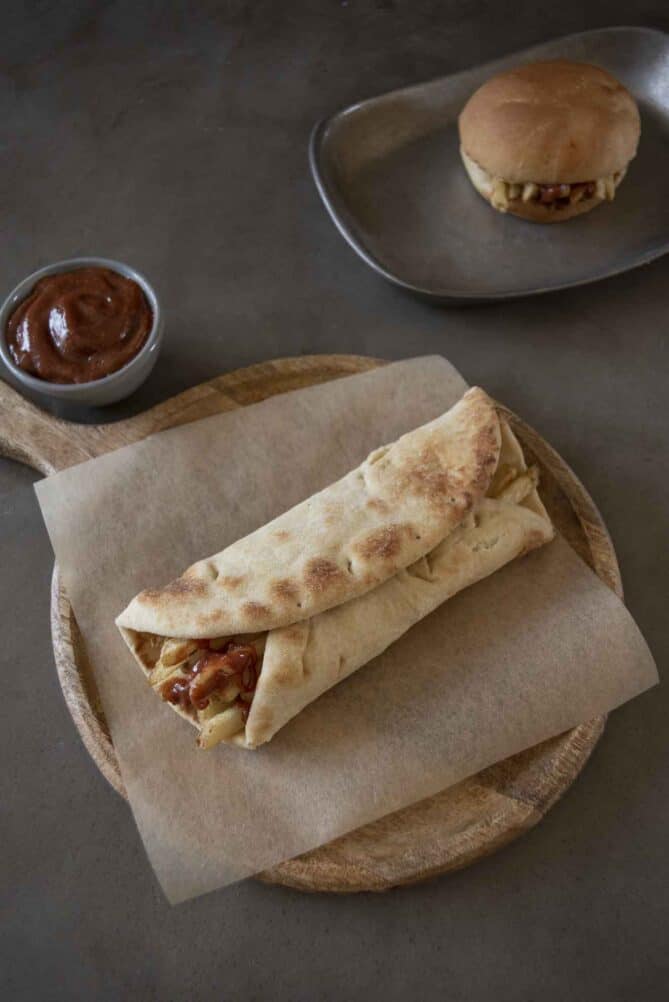 A piece of naan bread rolled up, filled with French Fries