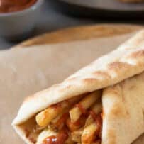 A gourmet British chip butty. Naan bread wrapped around chips/French fries and ketchup with Indian spices