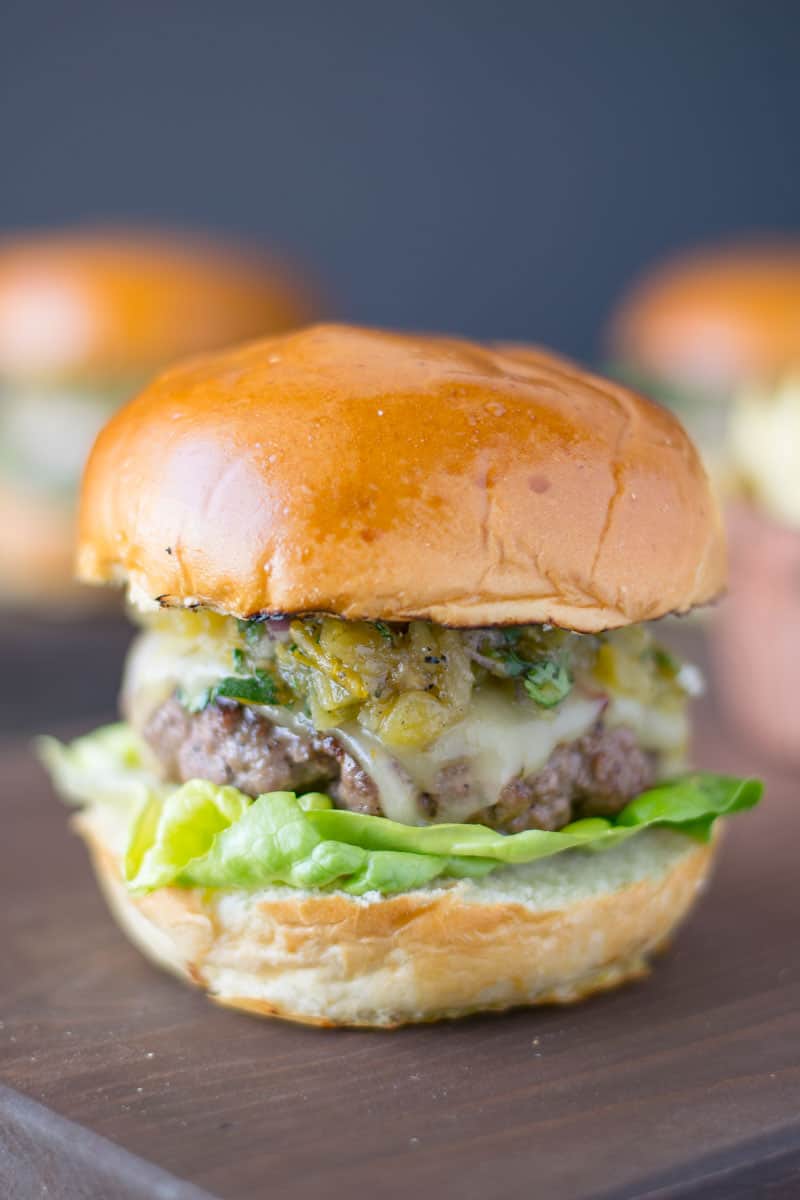 The burger from the side showing the melted cheese, chiles and lettuce