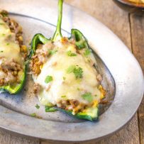 Grilled beef stuffed poblano peppers on a silver plate