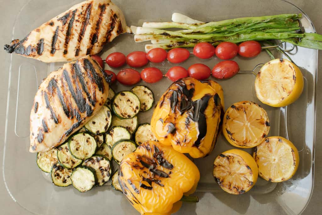 Grilled chicken and vegetables on a tray fresh off the grill