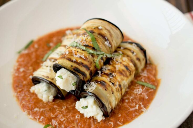 3 rolled sliced of eggplant filled with ricotta cheese
