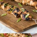 Grilled lemongrass chicken skewers on a board and over a bowl of noodles