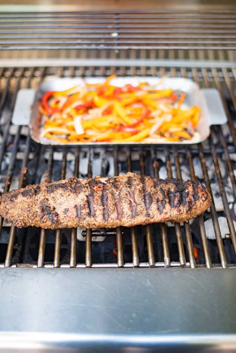 Grilled pork tenderloin fajitas are a quick and easy way to get a summer meal served in under 30 minutes. Marinated pork tenderloin is grilled along with onions and peppers. The pork is sliced then all are served on warm tortillas garnished with fresh avocado and cilantro.