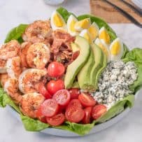 Grilled shrimp, tomato, bacon, avocado, egg and blue cheese on top of lettuce make up this grilled shrimp cobb salad